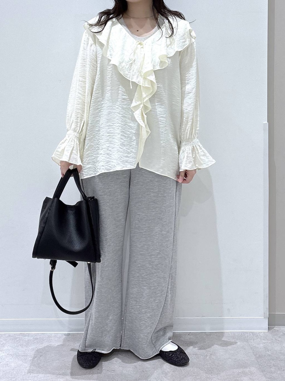 ブラック系のバレエシューズ、ブラック系のトートバッグ、グレー系のスウェットパンツを着用したレディースの春コーディネートの4枚目の写真