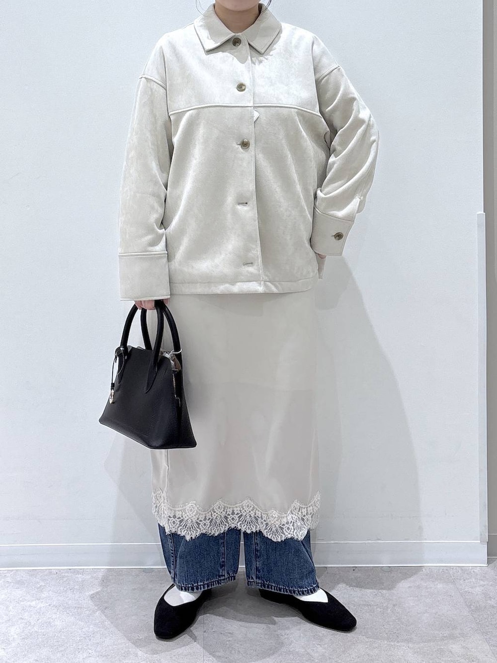 ブラック系のパンプス、ブラック系のショルダーバッグ、ベージュ系のテーラードジャケットを着用したレディースの春コーディネートの4枚目の写真