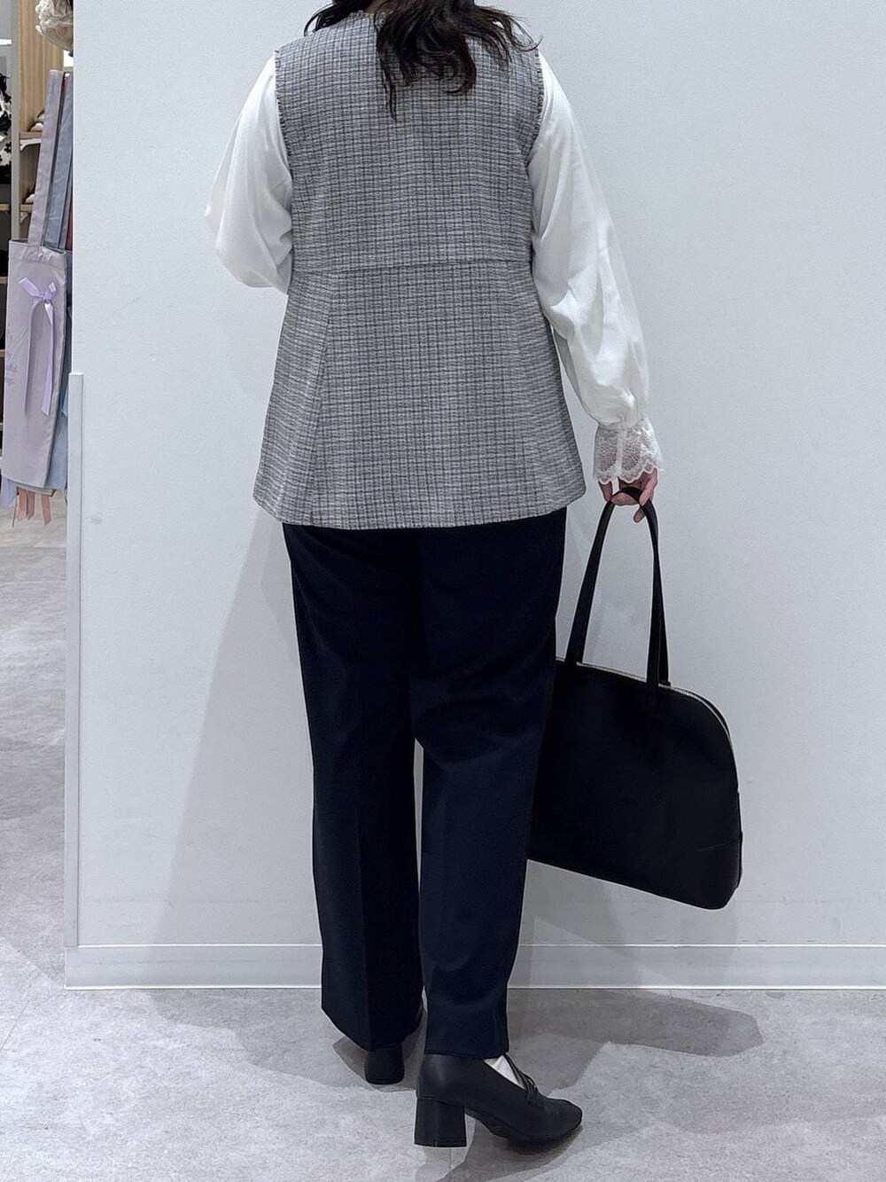 ブラック系のローファー、ホワイト系のシャツ/ブラウス、ブルー系のスラックスを着用したレディースの冬コーディネートの2枚目の写真