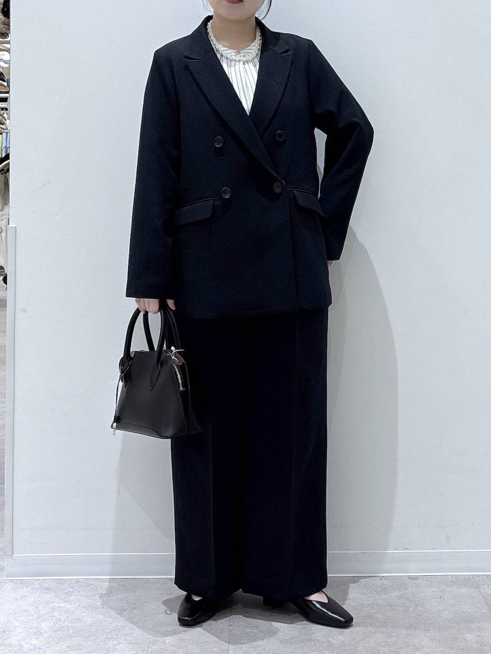 ブラック系のショルダーバッグ、ブラック系のパンプス、ブルー系のその他パンツを着用したレディースの冬コーディネートの4枚目の写真