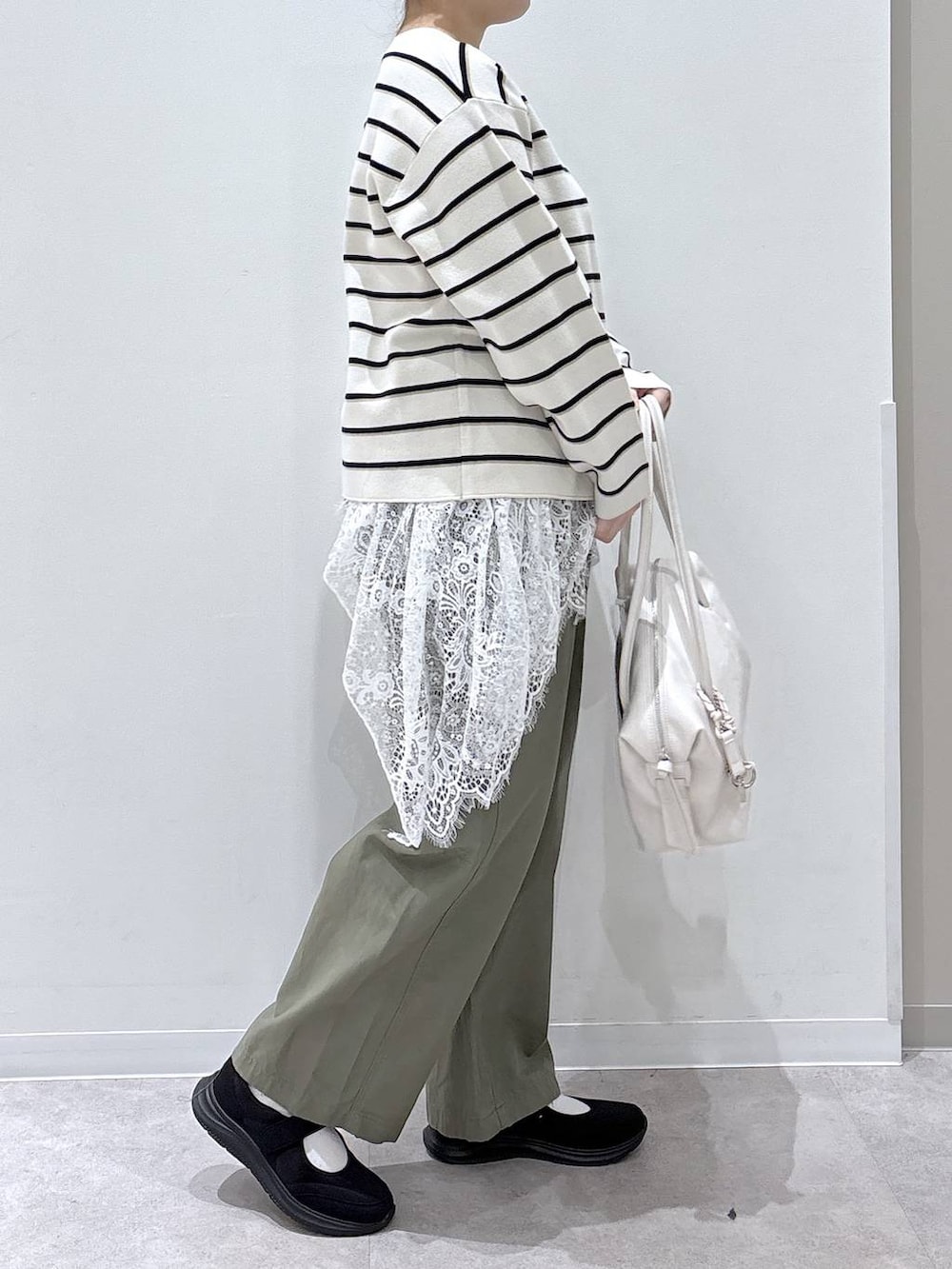 ホワイト系のボストンバッグ、ホワイト系のニット/セーター、ホワイト系のその他トップスを着用したレディースの春コーディネートの2枚目の写真