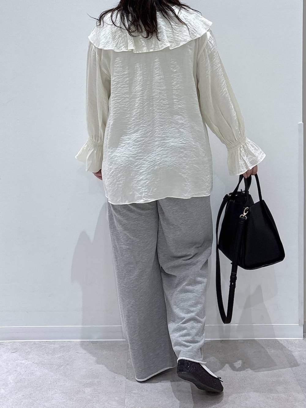 ブラック系のバレエシューズ、ブラック系のトートバッグ、グレー系のスウェットパンツを着用したレディースの春コーディネートの3枚目の写真