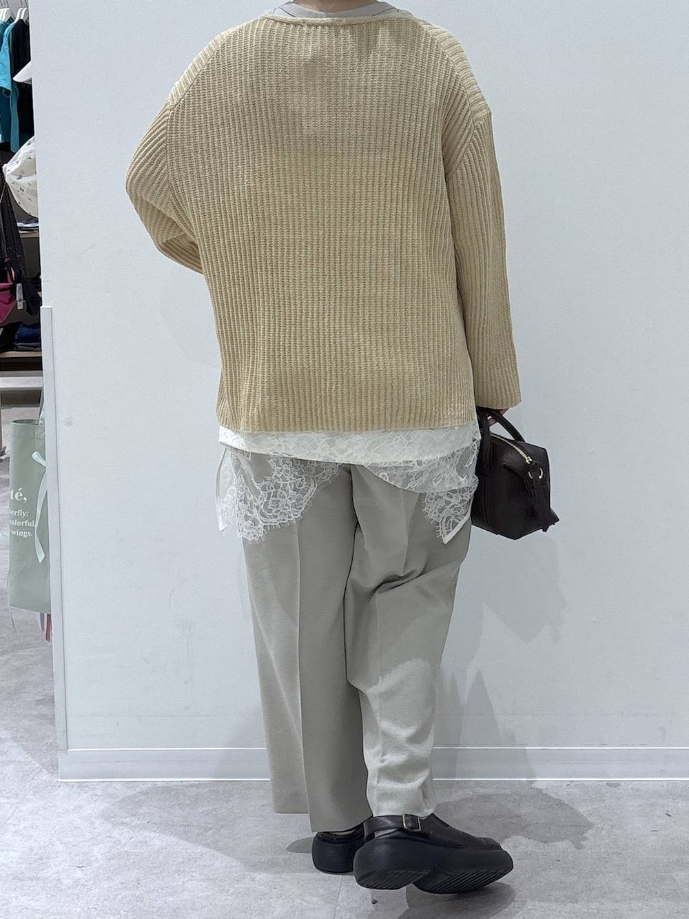ベージュ系のその他パンツ、ブラウン系のボストンバッグ、イエロー系のニット/セーターを着用したレディースの春コーディネートの3枚目の写真