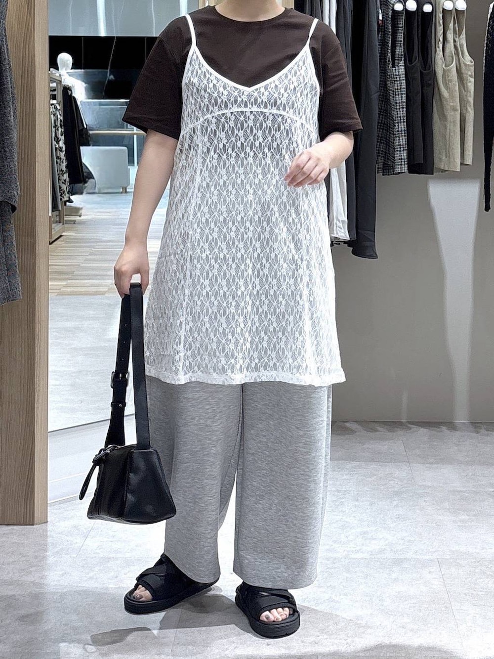 ブラウン系のショルダーバッグ、ブラウン系のTシャツ/カットソー、ブラック系のサンダルを着用したレディースの夏コーディネートの4枚目の写真