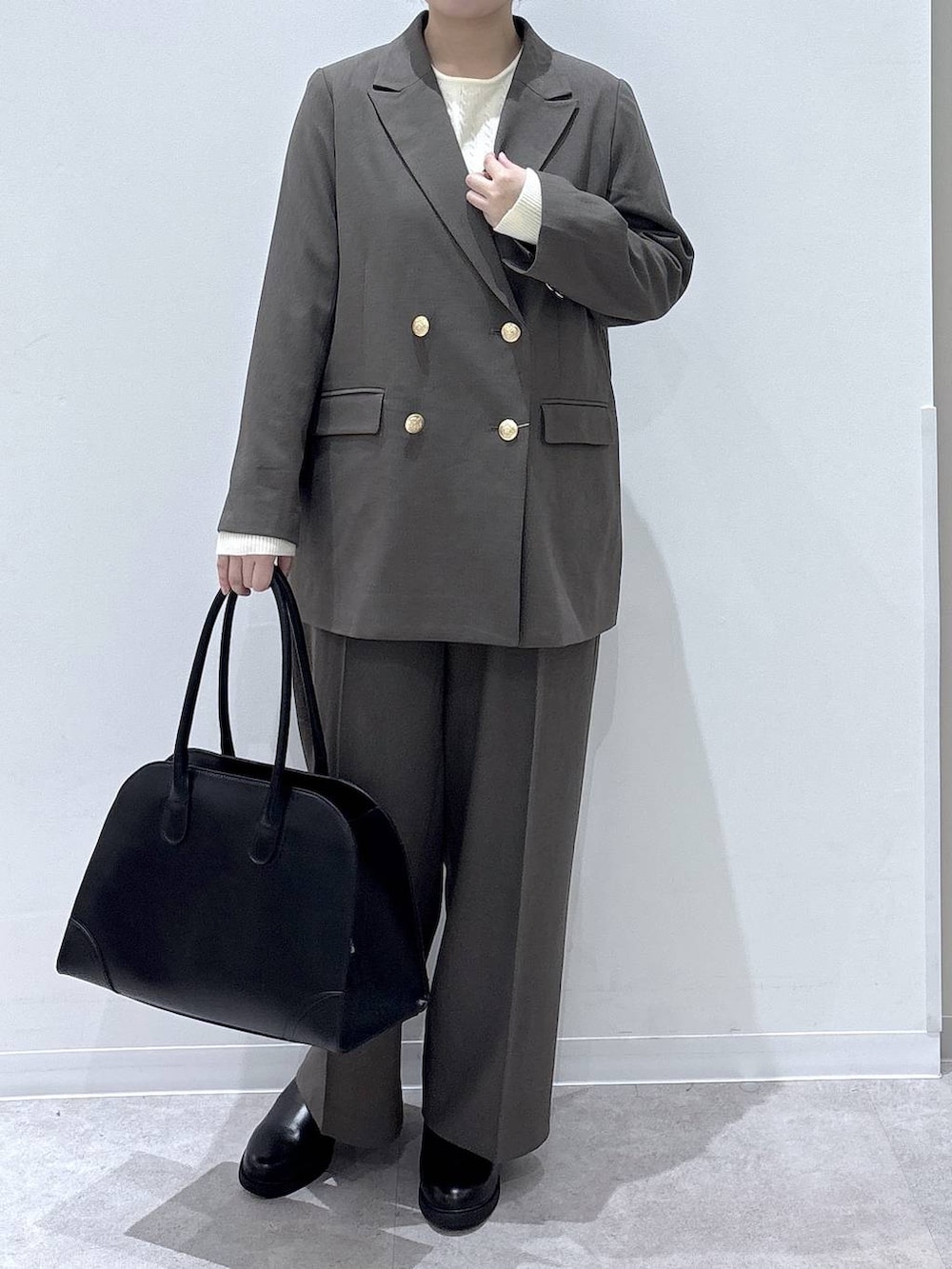 ブラック系のトートバッグ、ベージュ系のテーラードジャケット、ベージュ系のその他パンツを着用したレディースの秋コーディネートの4枚目の写真