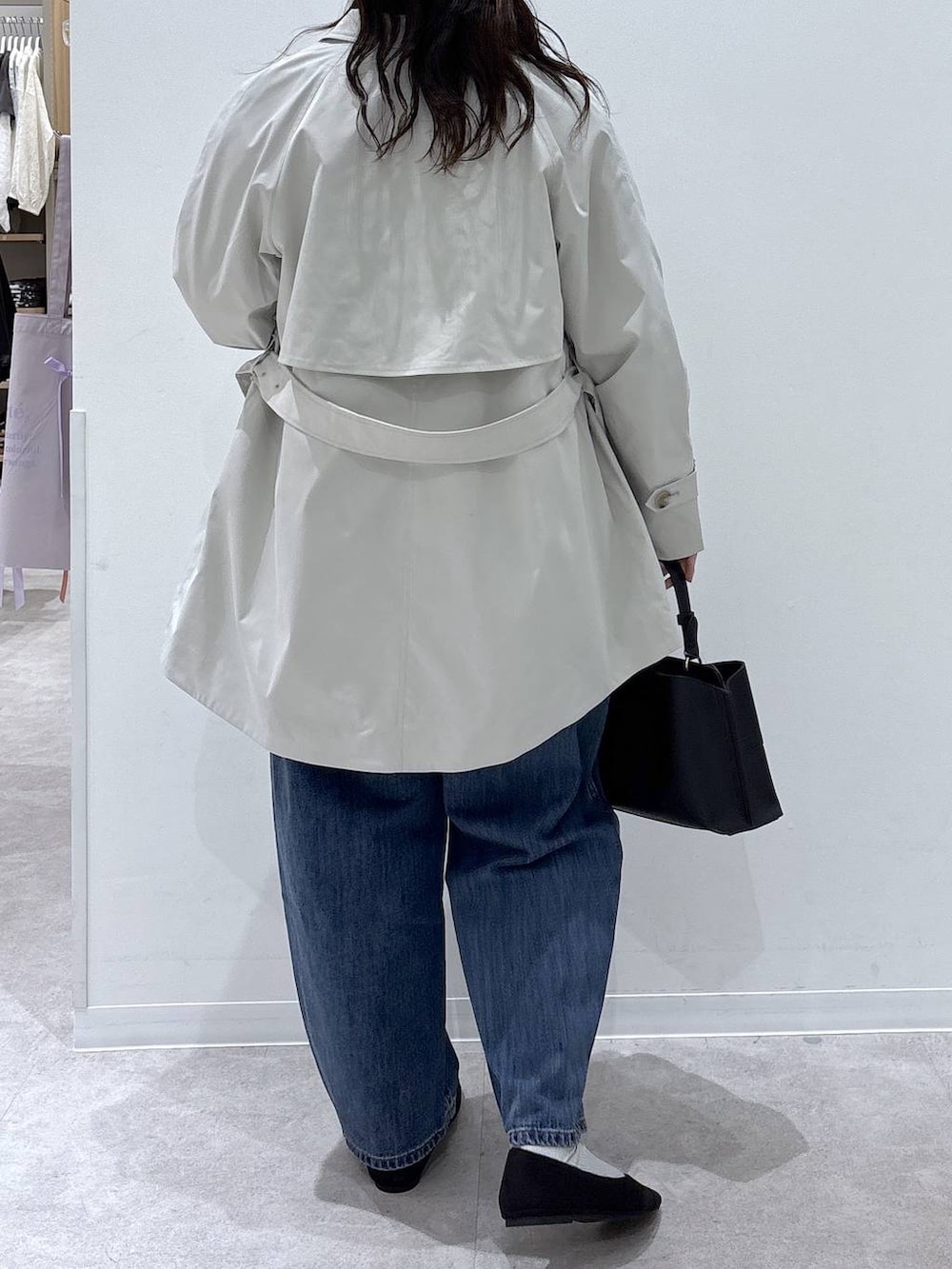 ブラック系のパンプス、ブルー系のデニムパンツ、ブラック系のショルダーバッグを着用したレディースの春コーディネートの3枚目の写真