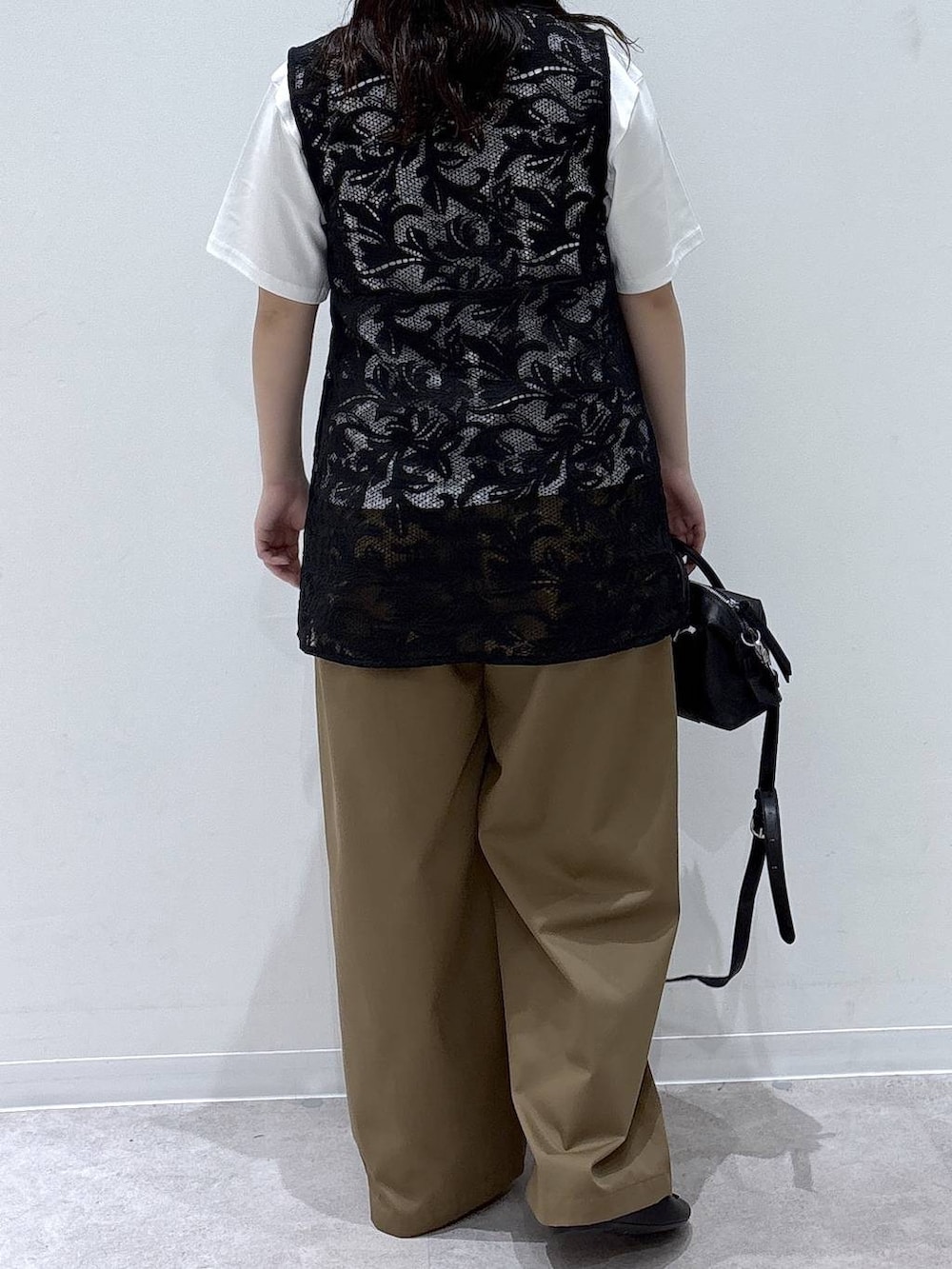 ブラック系のベスト、ブラック系のバレエシューズ、ホワイト系のTシャツ/カットソーを着用したレディースの夏コーディネートの3枚目の写真
