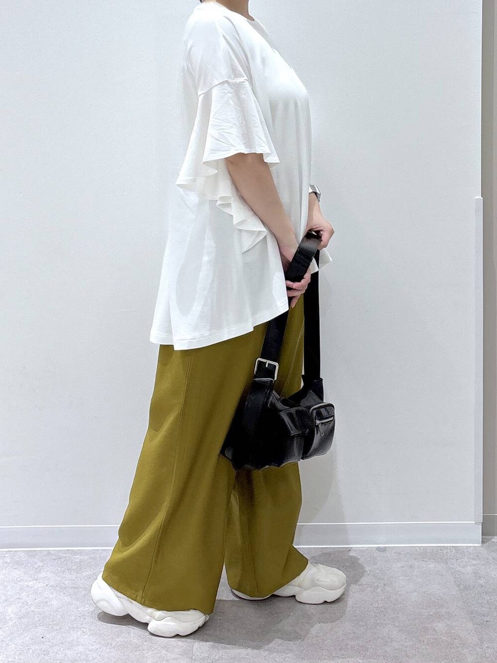 ブラック系のショルダーバッグ、ホワイト系のTシャツ/カットソーを着用したレディースの春コーディネートの2枚目の写真