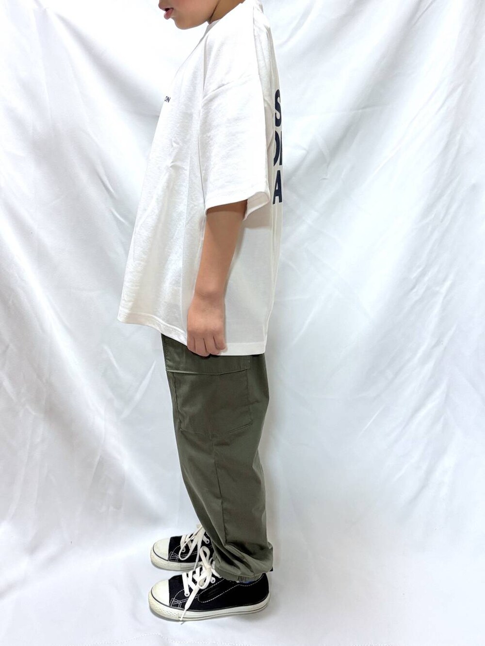 ホワイト系のTシャツ/カットソー、グリーン系のカーゴパンツを着用したキッズの秋コーディネートの2枚目の写真