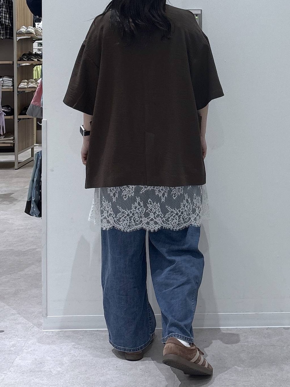 ブルー系のデニムパンツ、ブラウン系のテーラードジャケット、ホワイト系のタンクトップを着用したレディースの春コーディネートの3枚目の写真