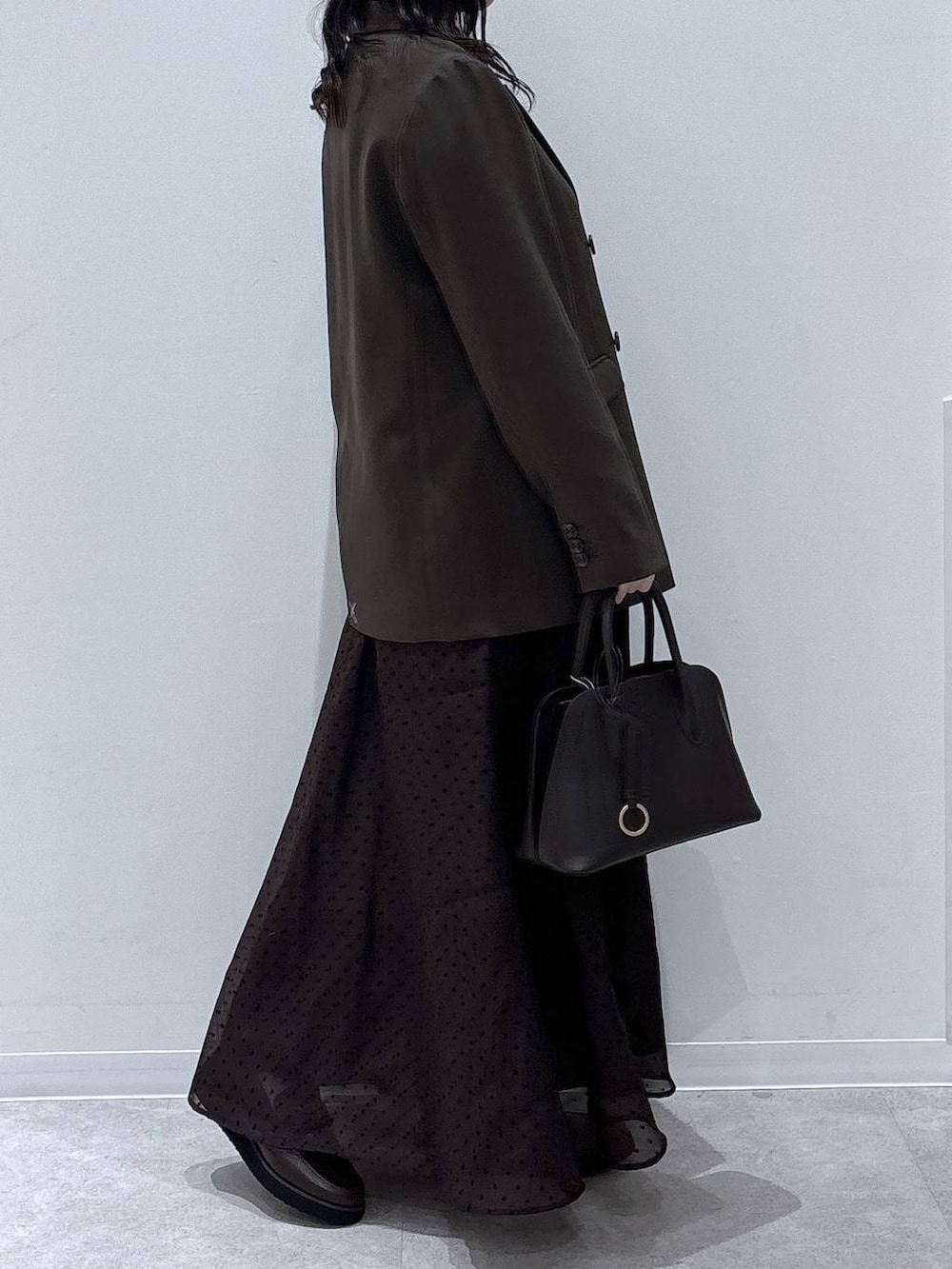 ブラウン系のショルダーバッグ、ブラウン系のテーラードジャケット、ブラウン系のスカートを着用したレディースの冬コーディネートの2枚目の写真