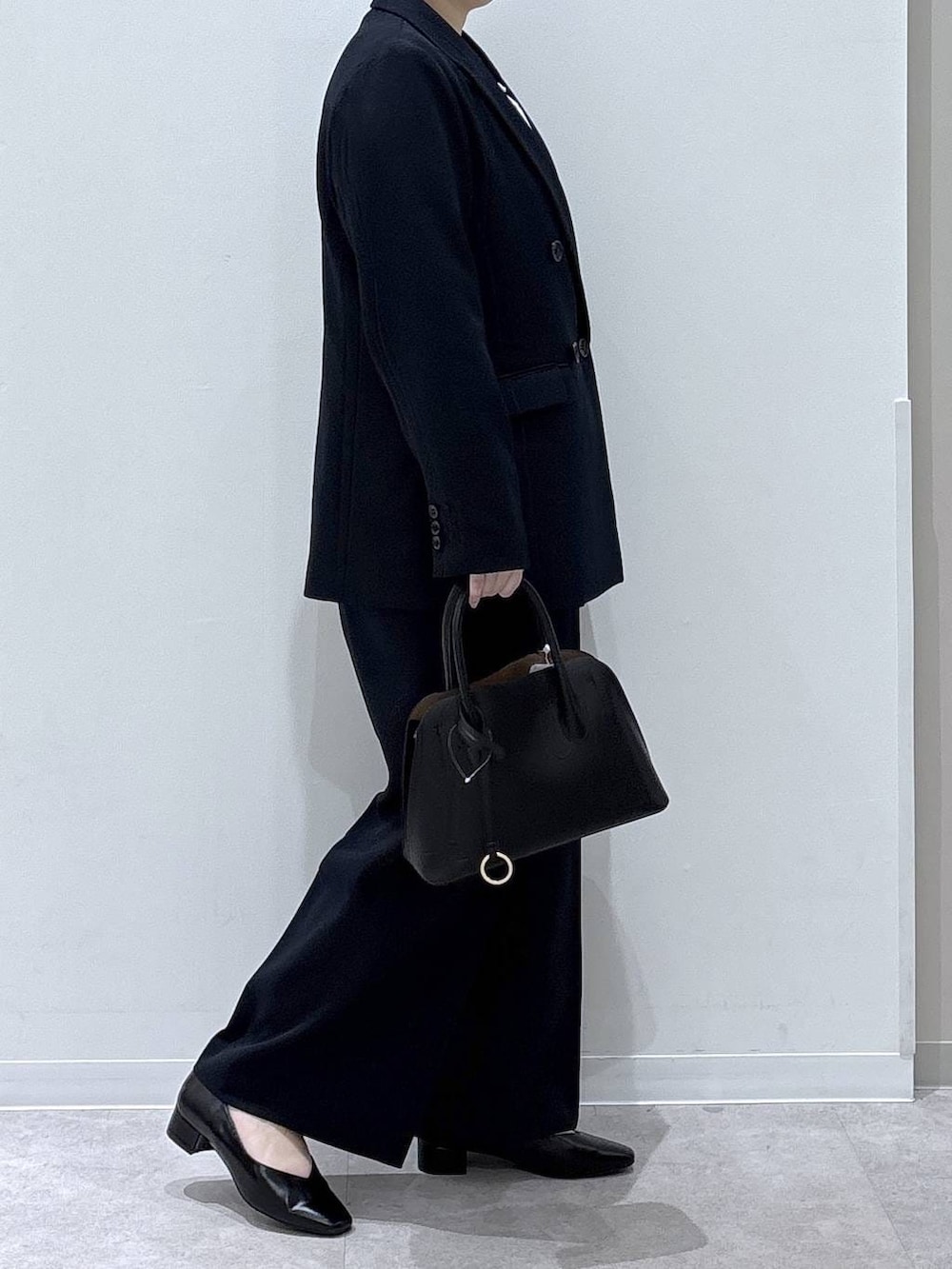 ブラック系のショルダーバッグ、ブラック系のパンプス、ブルー系のその他パンツを着用したレディースの冬コーディネートの2枚目の写真