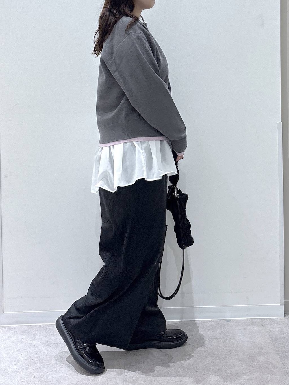 ホワイト系のTシャツ/カットソー、ブラック系のショルダーバッグ、グレー系のその他パンツを着用したレディースの秋コーディネートの2枚目の写真