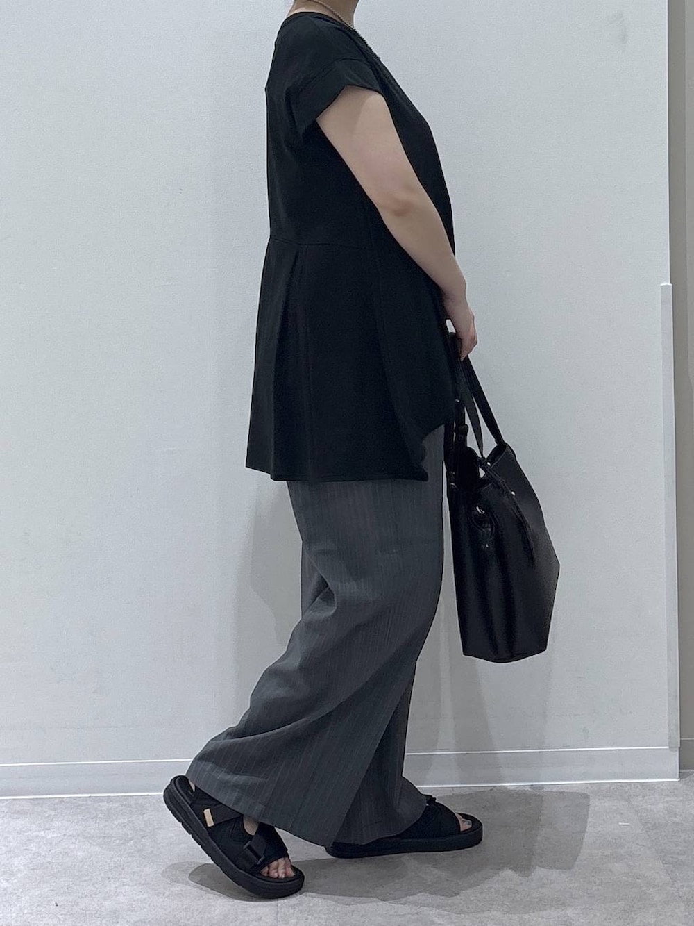 ブラック系のハンドバッグ、グレー系のその他パンツ、ブラック系のTシャツ/カットソーを着用したレディースの夏コーディネートの2枚目の写真