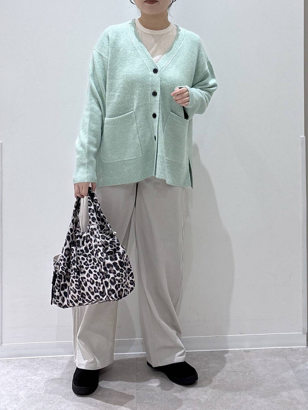 その他のトートバッグ、グリーン系のカーディガン/ボレロ、グレー系のその他パンツを着用したレディースの秋コーディネートの4枚目の写真