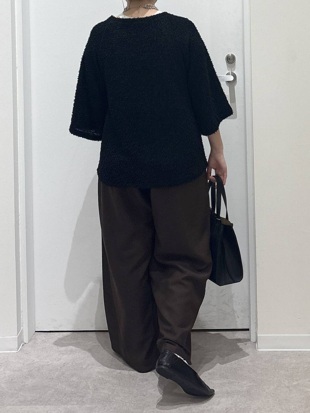 ブラック系のショルダーバッグ、ブラック系のパンプス、ブラウン系のその他パンツを着用したレディースの秋コーディネートの3枚目の写真
