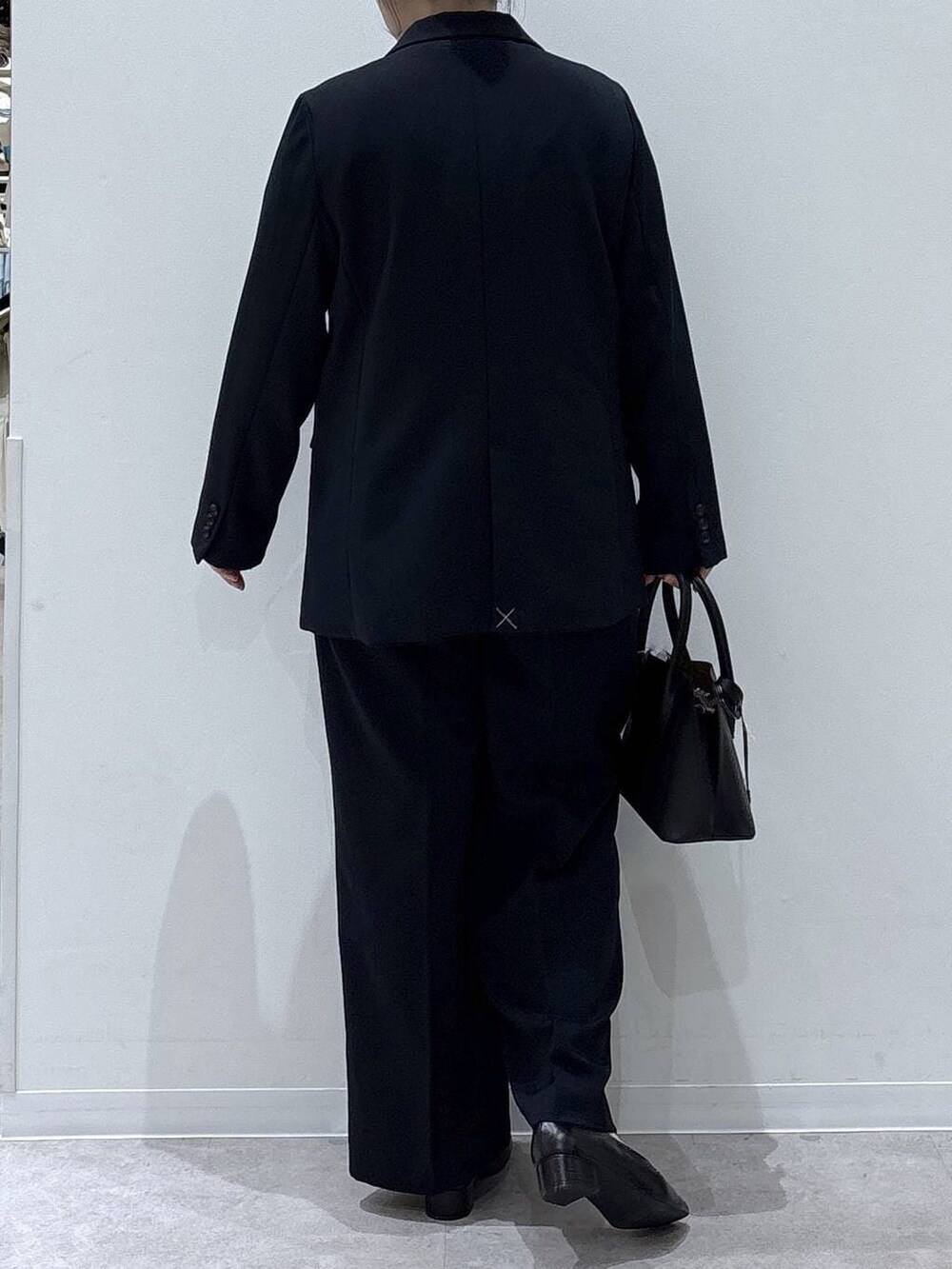 ブラック系のショルダーバッグ、ブラック系のパンプス、ブルー系のその他パンツを着用したレディースの冬コーディネートの3枚目の写真