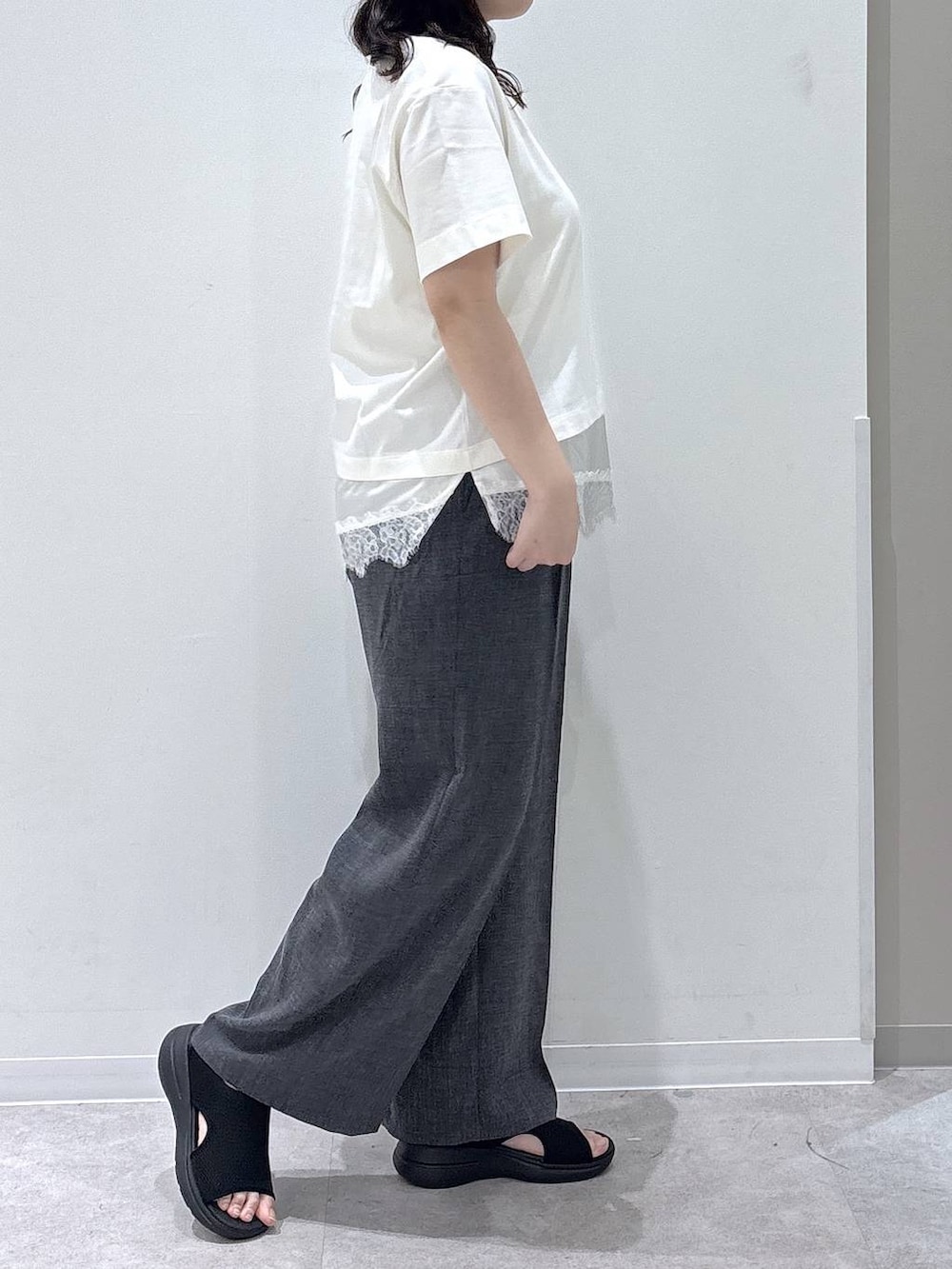 グレー系のその他パンツ、ブラック系のサンダル、ベージュ系のTシャツ/カットソーを着用したレディースの夏コーディネートの2枚目の写真