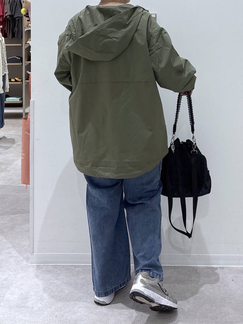 ブルー系のデニムパンツ、ホワイト系のTシャツ/カットソー、グリーン系のマウンテンパーカーを着用したレディースの秋コーディネートの4枚目の写真