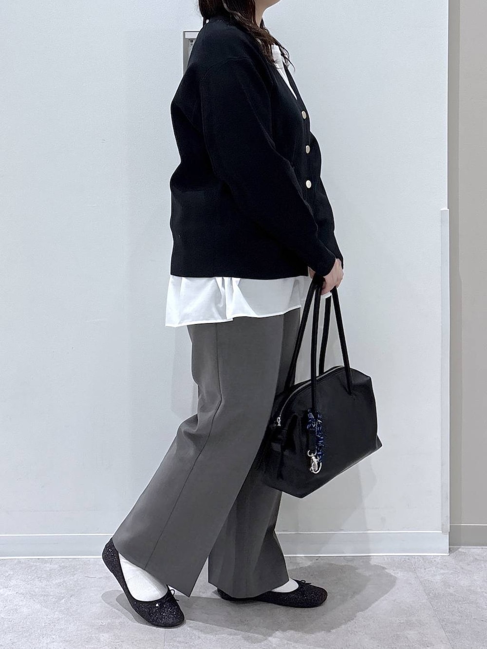 ブラック系のバレエシューズ、ブラック系のボストンバッグ、ブラウン系のその他パンツを着用したレディースの春コーディネートの2枚目の写真