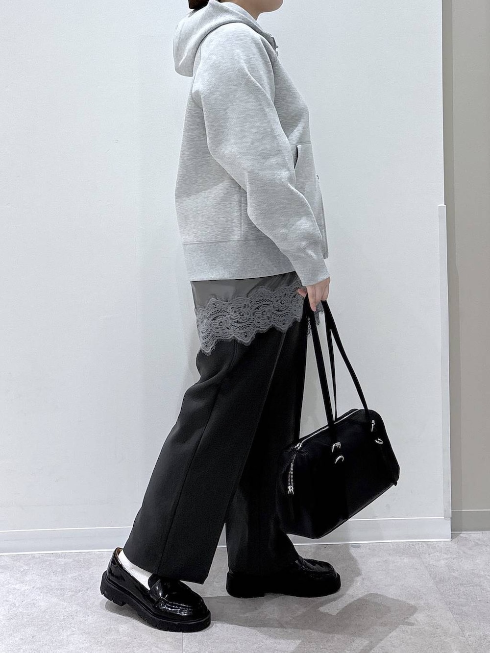 グレー系のパーカー、グレー系のその他パンツ、ブラック系のショルダーバッグを着用したレディースの春コーディネートの2枚目の写真
