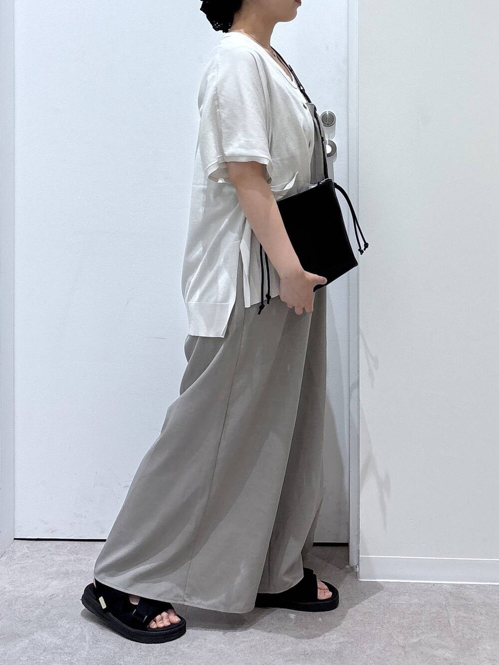 ベージュ系のカーディガン/ボレロ、ブラック系のサンダル、グレー系のサロペット/オーバーオールを着用したレディースの夏コーディネートの2枚目の写真