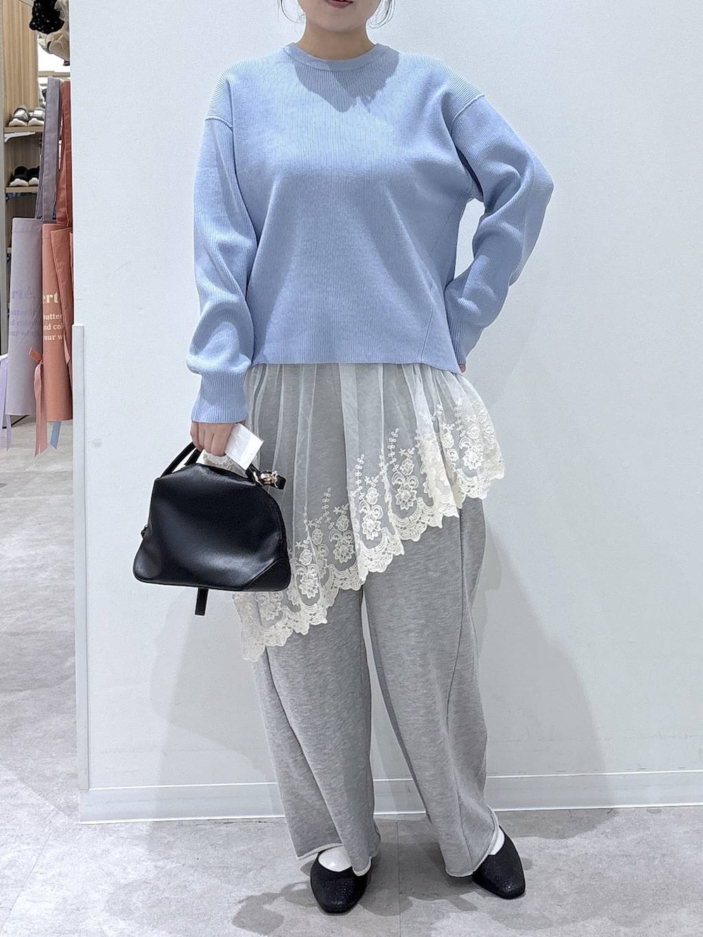 ブラック系のパンプス、ブルー系のニット/セーター、グレー系のスウェットパンツを着用したレディースの冬コーディネートの3枚目の写真