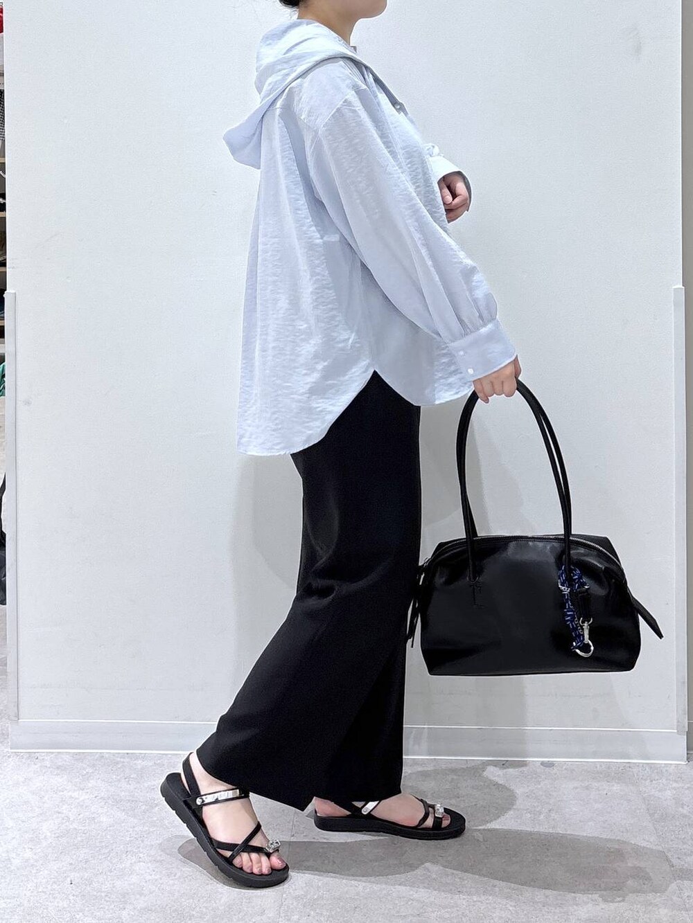 ブラック系のボストンバッグ、ブラック系のその他パンツ、ブルー系のTシャツ/カットソーを着用したレディースの夏コーディネートの2枚目の写真
