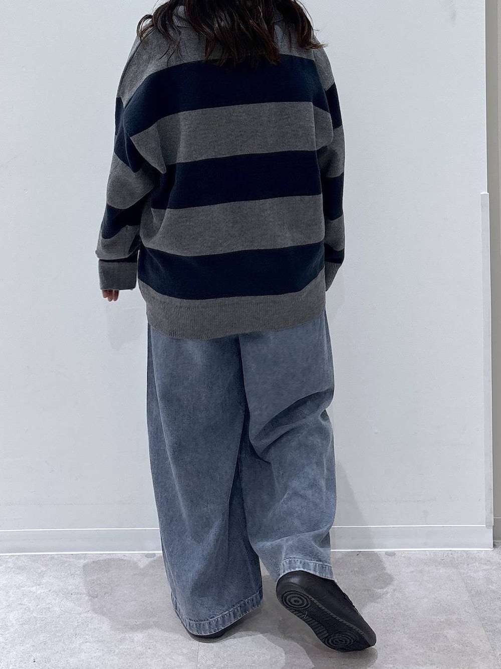ブラック系のローファー、グレー系のニット/セーター、ブルー系のデニムパンツを着用したレディースの秋コーディネートの3枚目の写真