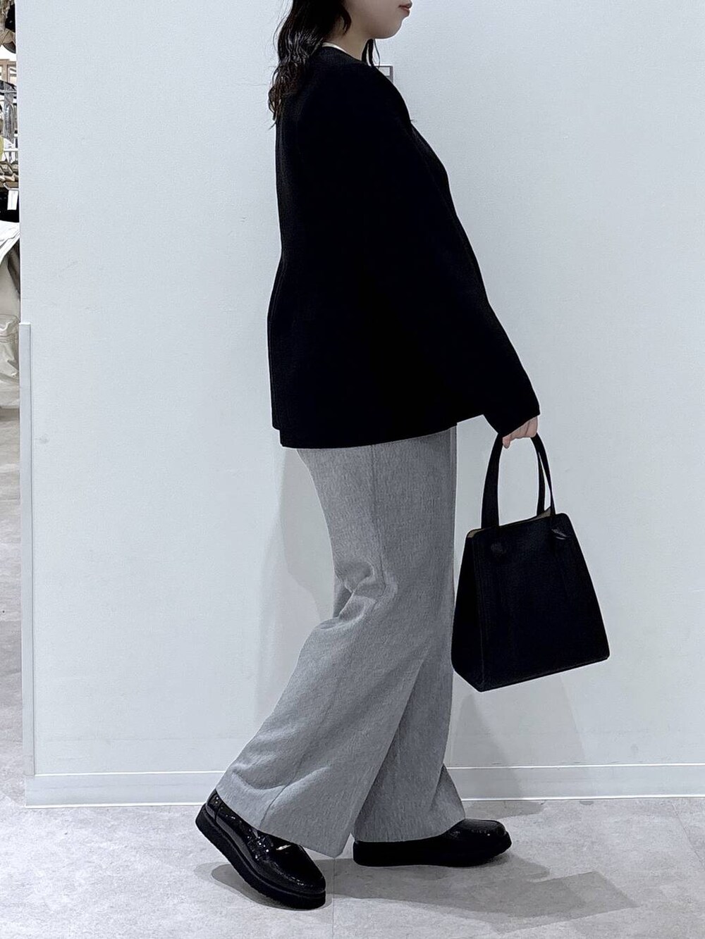 ブラック系のローファー、ブラック系のショルダーバッグ、グレー系のその他パンツを着用したレディースの冬コーディネートの2枚目の写真