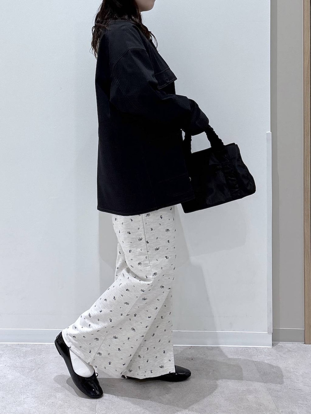 ブラック系のバレエシューズ、ブラック系のショルダーバッグ、ブルー系のブルゾンを着用したレディースの春コーディネートの2枚目の写真