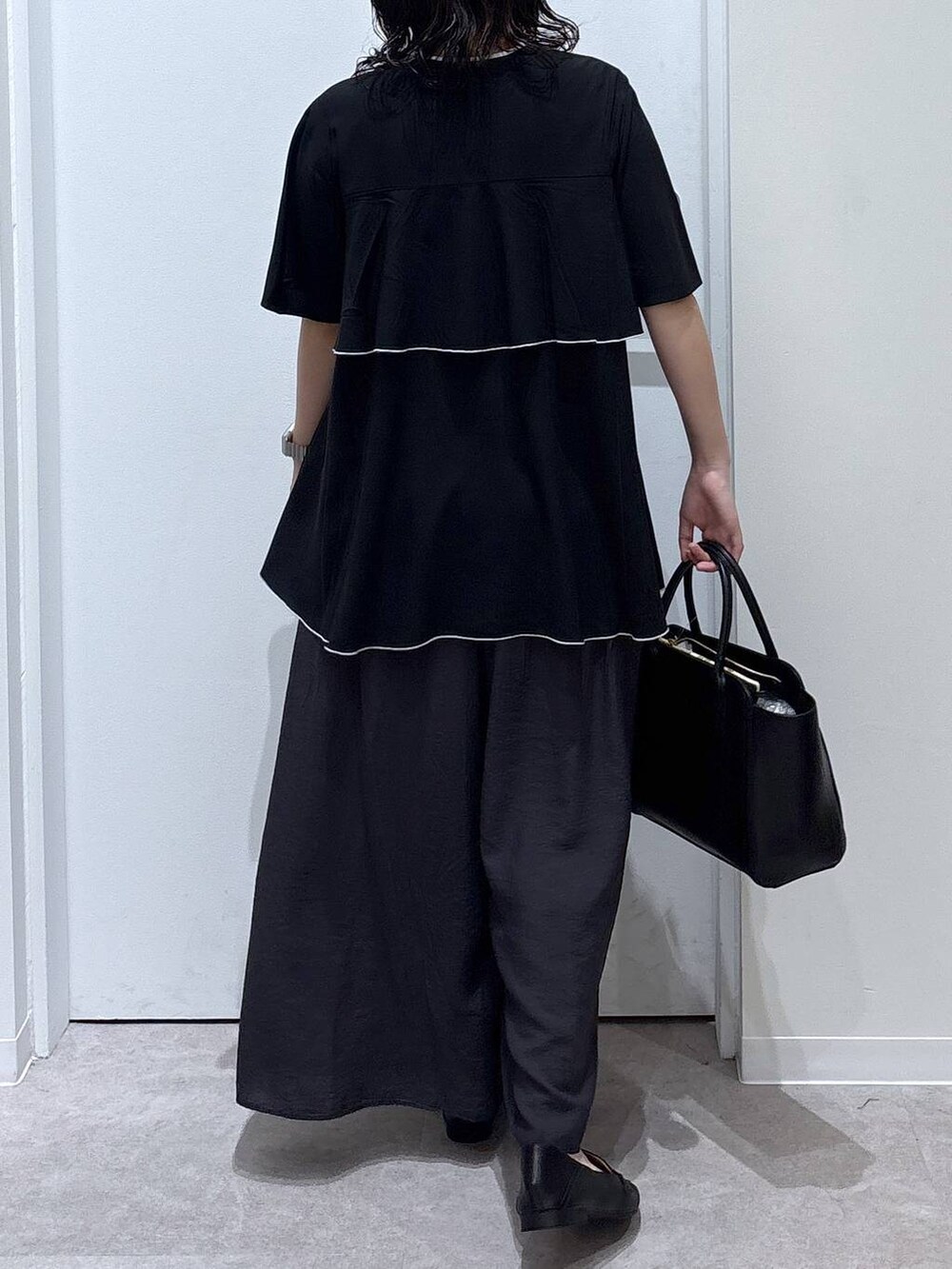 ブラック系のローファー、ブラック系のショルダーバッグ、ブラック系のシャツ/ブラウスを着用したレディースの夏コーディネートの3枚目の写真