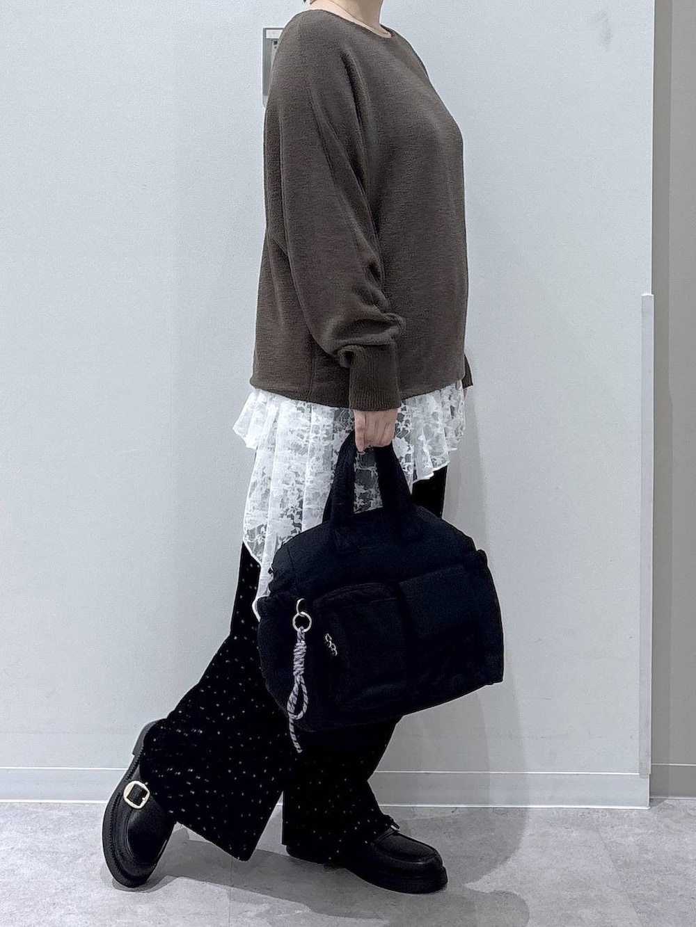 ブラック系のトートバッグ、ブラック系のその他パンツ、グリーン系のニット/セーターを着用したレディースの秋コーディネートの2枚目の写真