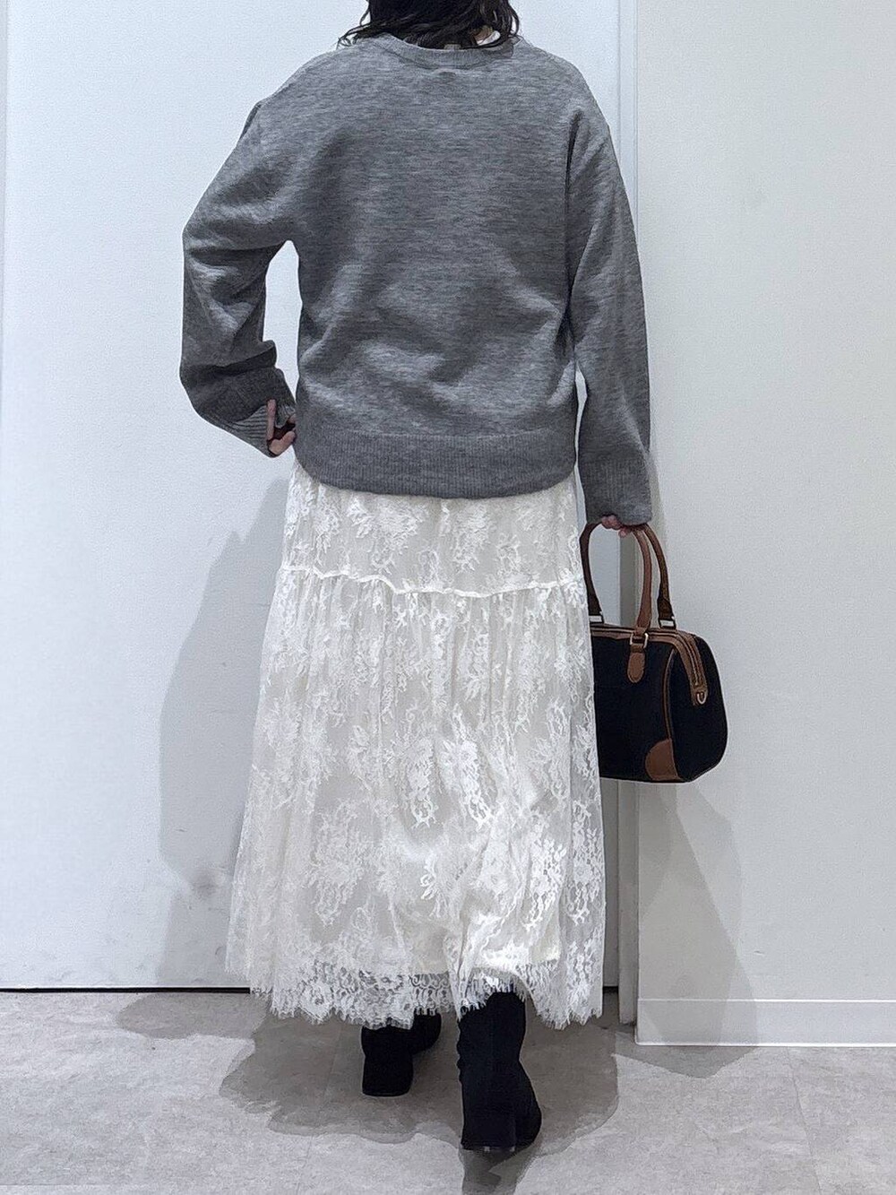 ベージュ系のノーカラーコート、グレー系のワンピース、ブラック系のボストンバッグを着用したレディースの秋コーディネートの6枚目の写真