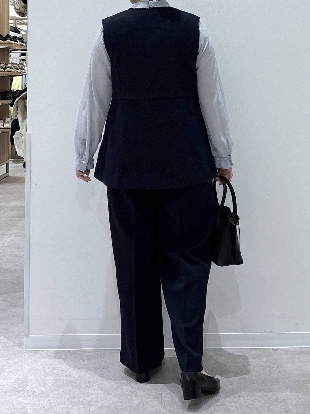 ブラック系のショルダーバッグ、ブラック系のパンプス、ブルー系のその他アウターを着用したレディースの冬コーディネートの3枚目の写真