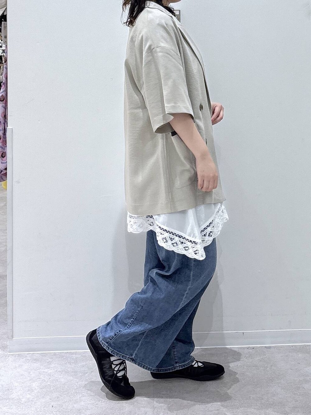 ブルー系のデニムパンツ、ベージュ系のテーラードジャケット、ブラウン系のTシャツ/カットソーを着用したレディースの夏コーディネートの2枚目の写真