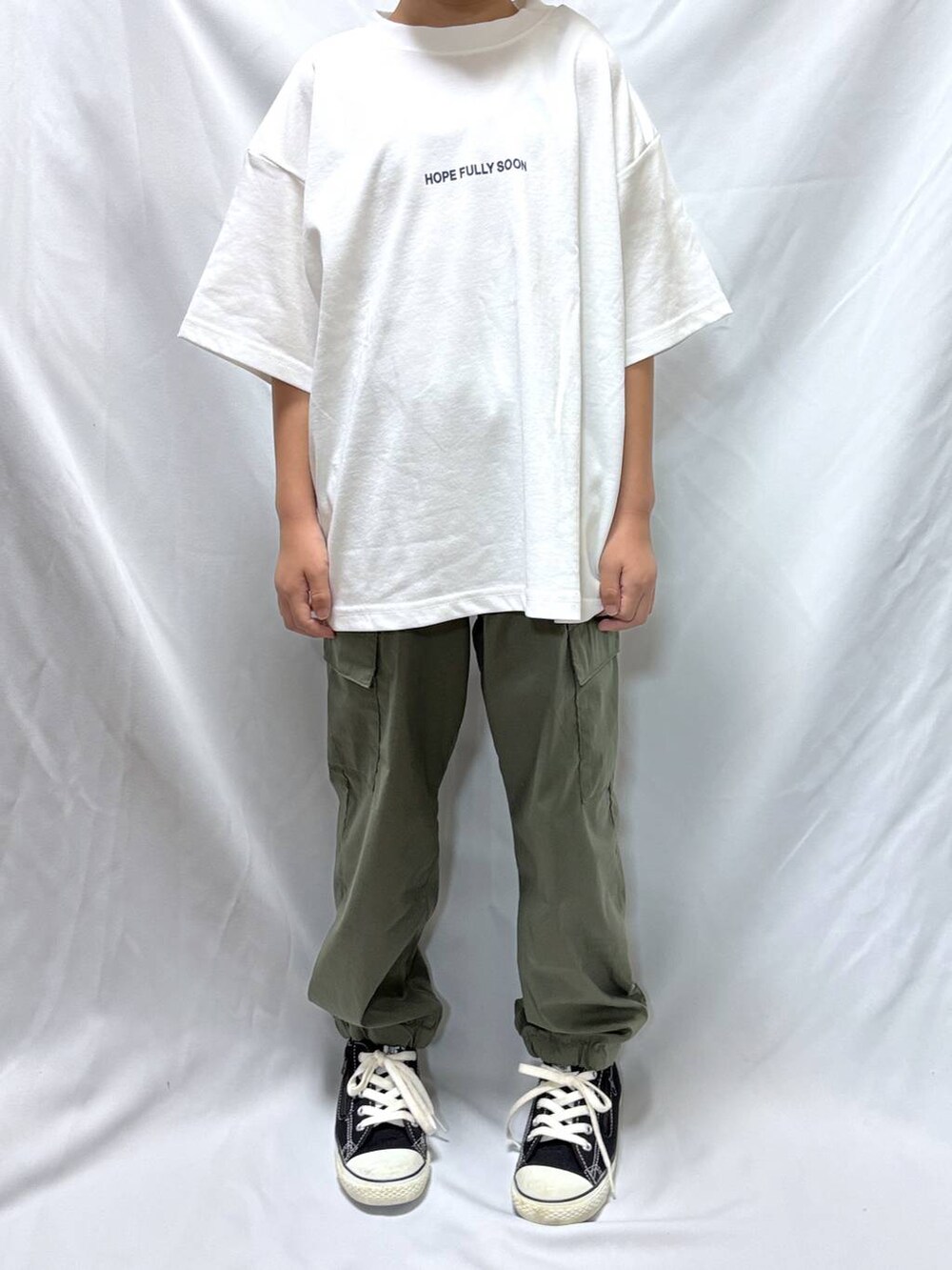 ホワイト系のTシャツ/カットソー、グリーン系のカーゴパンツを着用したキッズの秋コーディネートの3枚目の写真