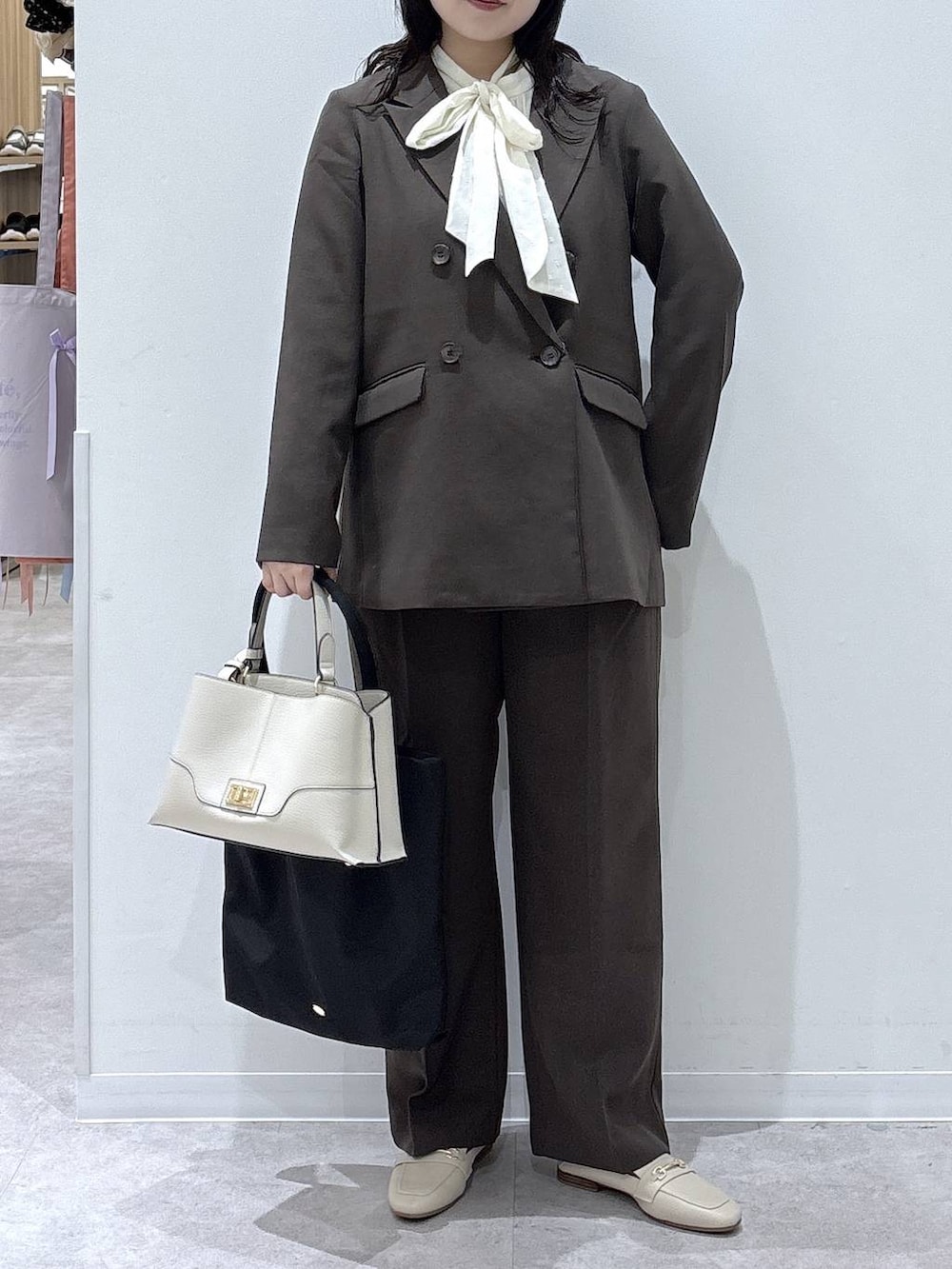 ホワイト系のシャツ/ブラウス、ブラック系のトートバッグ、ブラウン系のテーラードジャケットを着用したレディースの冬コーディネートの4枚目の写真