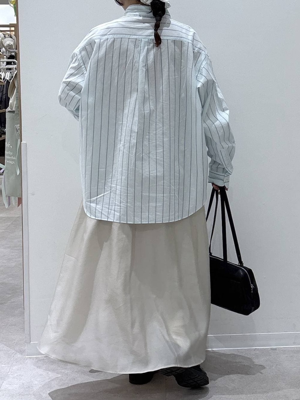 ベージュ系のスカート、ブラック系のショルダーバッグ、ブルー系のシャツ/ブラウスを着用したレディースの春コーディネートの3枚目の写真