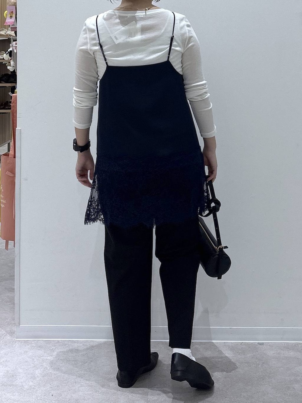 ブラック系のパンプス、ブラック系のクラッチバッグ、ホワイト系のTシャツ/カットソーを着用したレディースの秋コーディネートの2枚目の写真