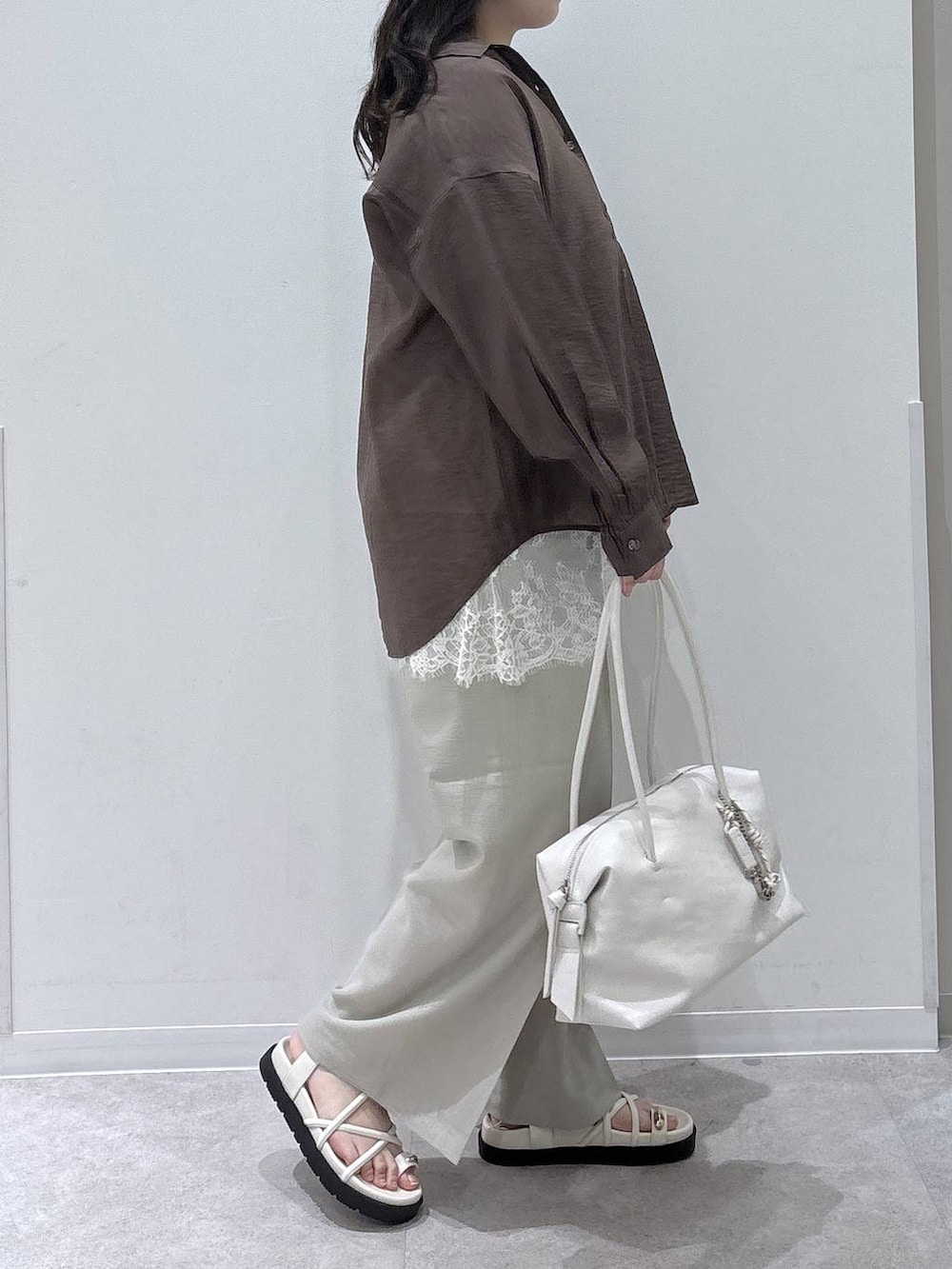 ホワイト系のボストンバッグ、ベージュ系のその他パンツ、ブラウン系のシャツ/ブラウスを着用したレディースの春コーディネートの2枚目の写真