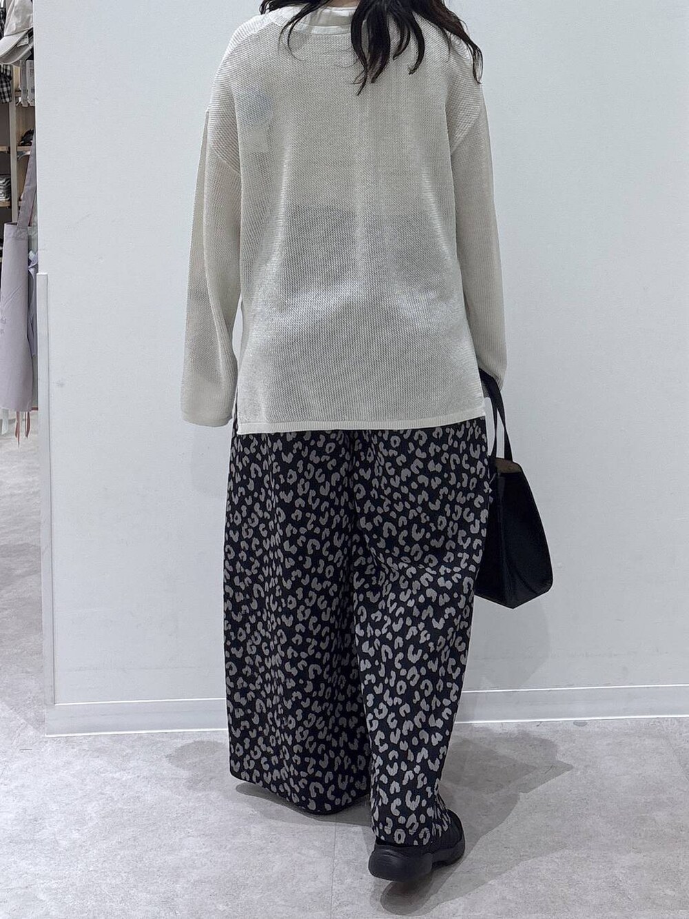 ブラック系のショルダーバッグ、その他のその他パンツ、ホワイト系のニット/セーターを着用したレディースの春コーディネートの3枚目の写真