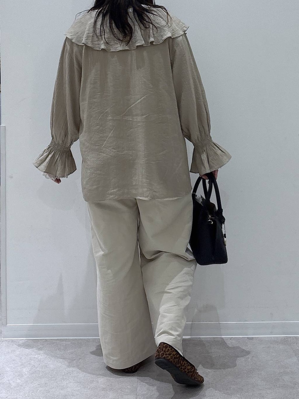 ブラック系のショルダーバッグ、ホワイト系のその他パンツ、ベージュ系のシャツ/ブラウスを着用したレディースの春コーディネートの3枚目の写真