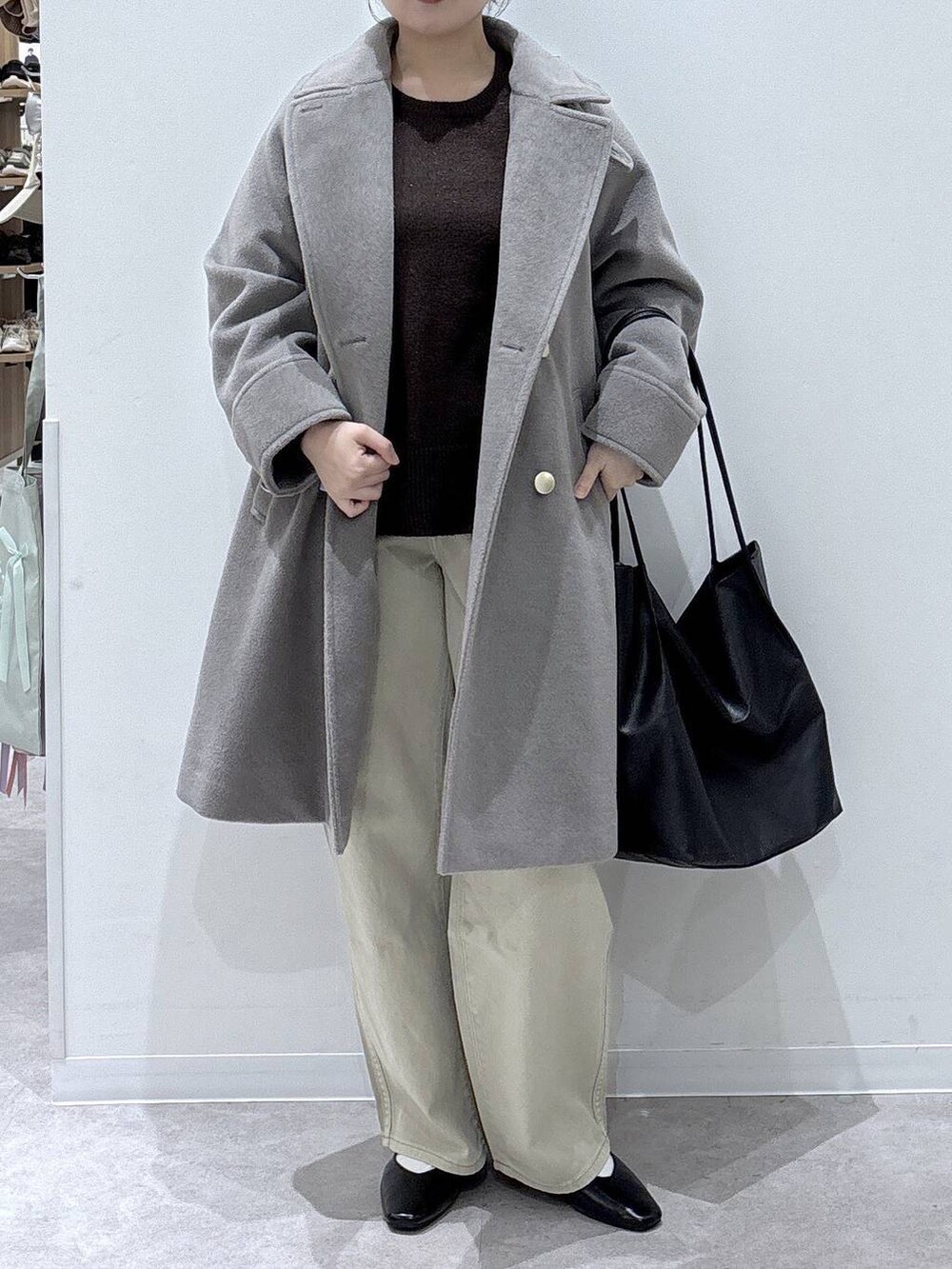 ブラック系のパンプス、ベージュ系のデニムパンツ、ベージュ系のチェスターコートを着用したレディースの冬コーディネートの4枚目の写真