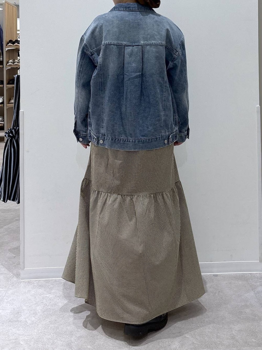 ブルー系のデニムジャケット、イエロー系のワンピースを着用したレディースの春コーディネートの3枚目の写真