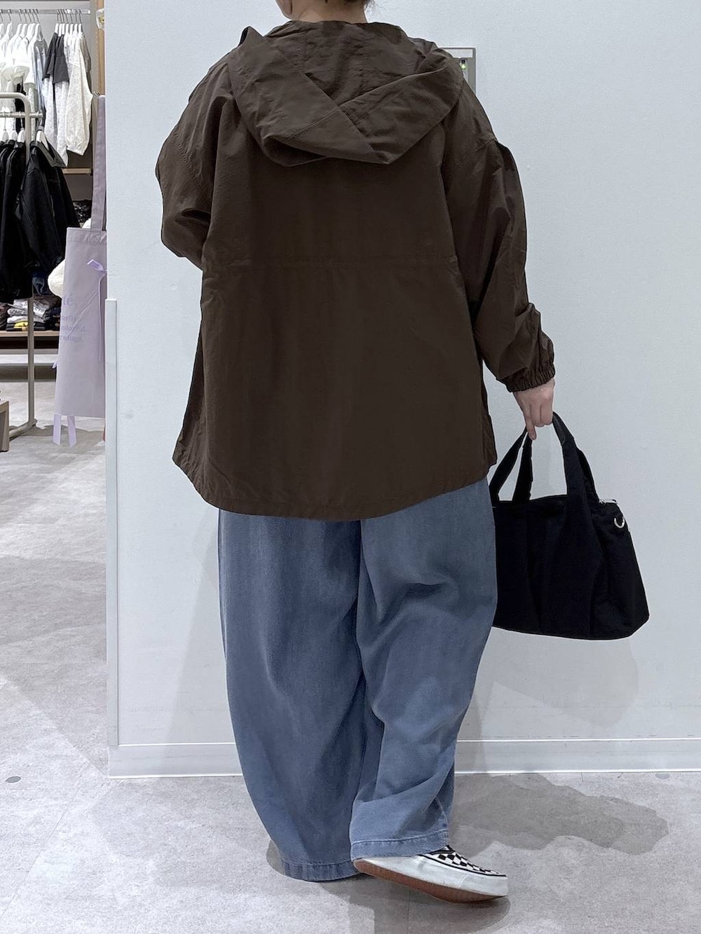 ブラック系のトートバッグ、グリーン系のマウンテンパーカー、ピンク系のニット/セーターを着用したレディースの春コーディネートの3枚目の写真