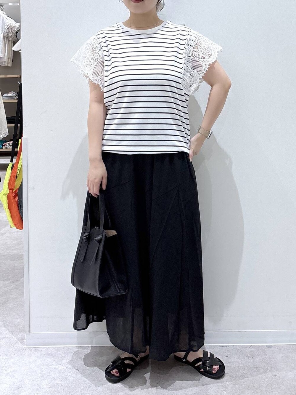 ブラック系のショルダーバッグ、グレー系のスカート、ホワイト系のTシャツ/カットソーを着用したレディースの夏コーディネートの4枚目の写真