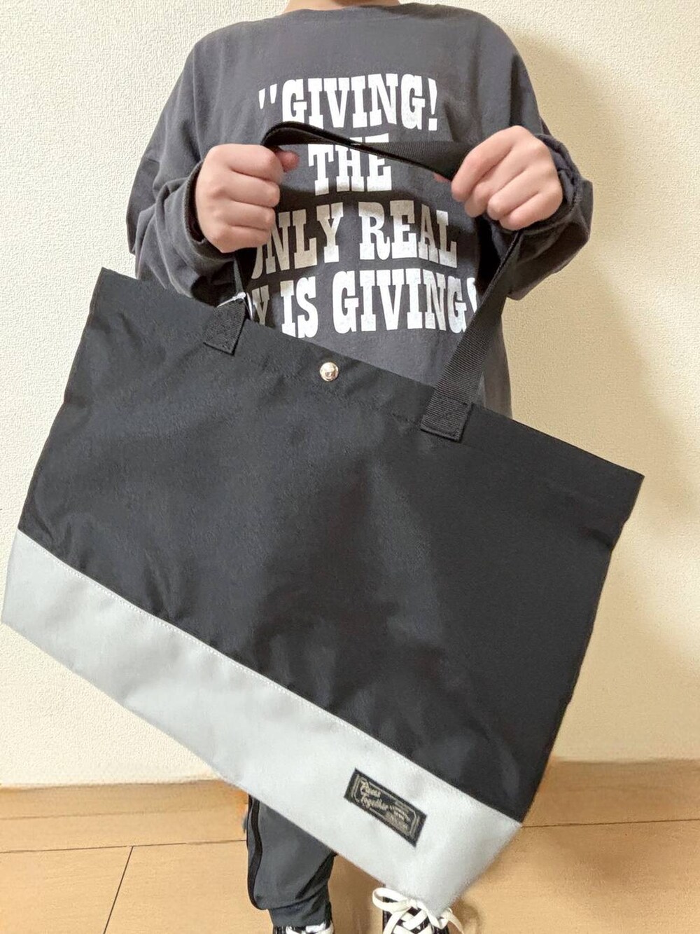 ブルー系のスウェットパンツ、グレー系のTシャツ/カットソー、ブラック系のトートバッグを着用したキッズの冬コーディネートの3枚目の写真