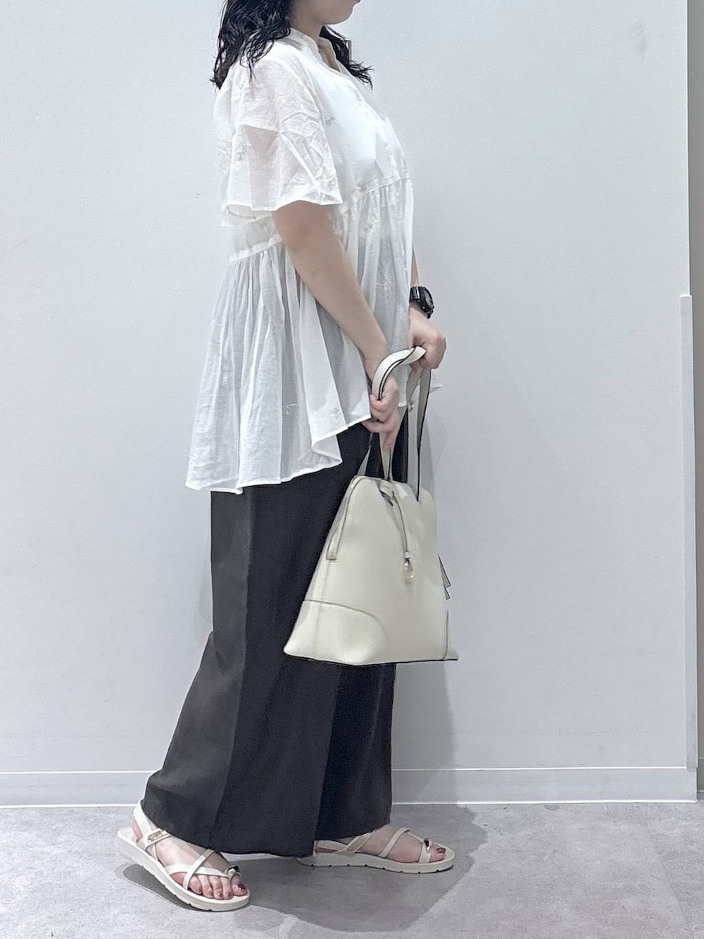 ブラウン系のその他パンツ、ベージュ系のボストンバッグ、ホワイト系のサンダルを着用したレディースの夏コーディネートの2枚目の写真