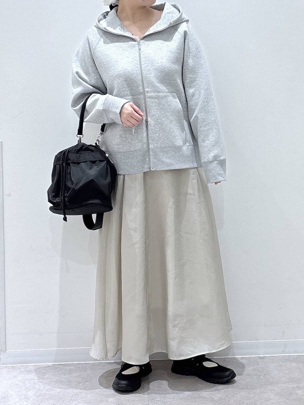 ブラック系のスニーカー、ブラック系のショルダーバッグ、グレー系のパーカーを着用したレディースの春コーディネートの4枚目の写真